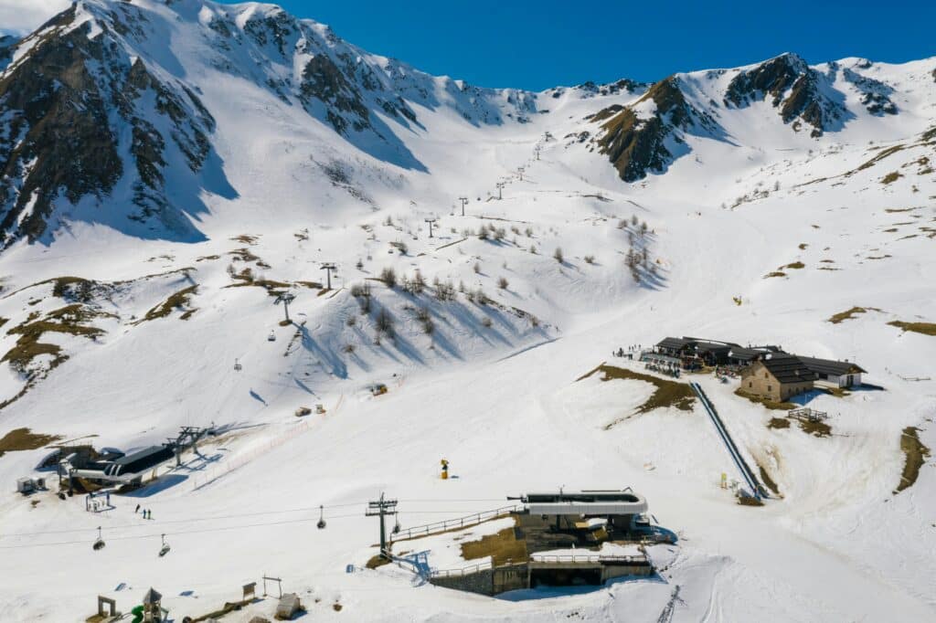 An aerial shot of a scenic ski resort nestled in snow-covered alpine mountains during winter.